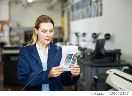 Portrait of a happy woman with color chart in her hand Portrait of a happy woman with color chart in her hand 129032397