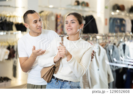 Couple man and woman choosing clothes 129032608