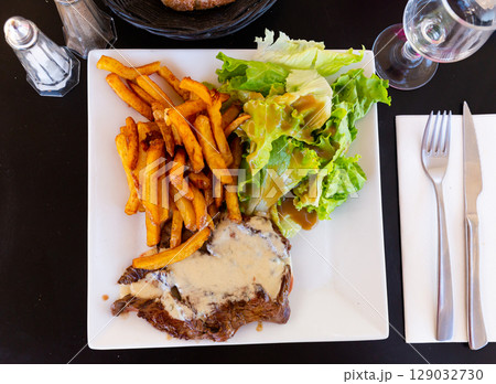 Beef steak with Roquefort sauce served with baked potatoes 129032730