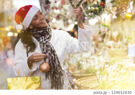 Positive woman selecting gifts at christmas fair Positive woman selecting gifts at christmas fair 129032830