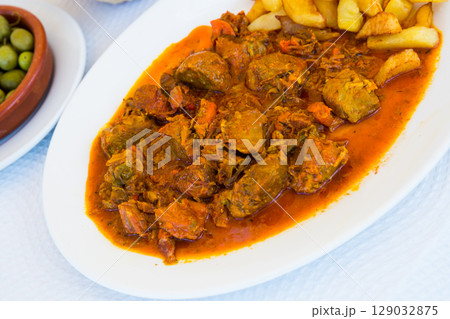 Close up of delicious baked in sauce pork cheeks served with potatoes Close up of delicious baked in sauce pork cheeks served with potatoes 129032875