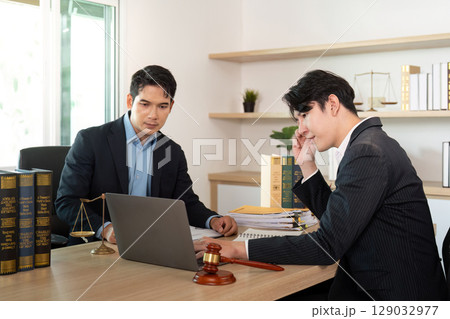 Focused Legal Discussion. Lawyer and client analyzing case details in office. Focused Legal Discussion. Lawyer and client analyzing case details in office. 129032977