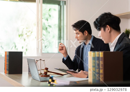 Legal Consultation. Two lawyers discussing case details in modern office. 129032978