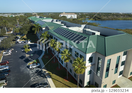 Top view of residential condo in USA with rooftop covered with solar photovoltaic panels for producing of clean ecological electrical energy. Concept of autonomous home Top view of residential condo in USA with rooftop covered with solar photovoltaic panels for producing of clean ecological electrical energy. Concept of autonomous home 129033234