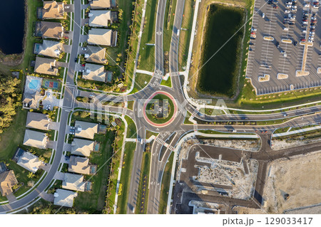 Roundabout crossroads on American city street with moving traffic cars. Circular transportation crossroads in USA 129033417