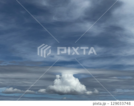 Towering Cumulus Cloud Beneath Swirling Blue and Gray Sky Towering Cumulus Cloud Beneath Swirling Blue and Gray Sky 129033748