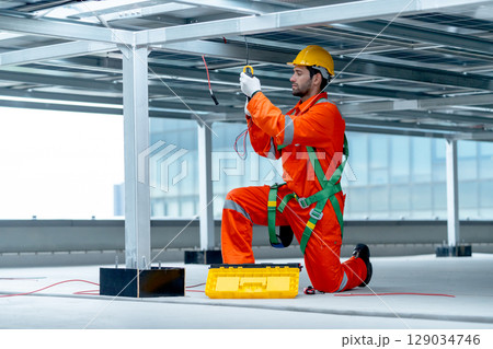 Wide shot of professional technician worker or engineer use tools to maintenance or check system under solarcell panel. Wide shot of professional technician worker or engineer use tools to maintenance or check system under solarcell panel. 129034746