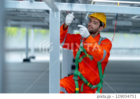 Front view professional technician worker or engineer work with maintenance or check system under solar cell panel. Front view professional technician worker or engineer work with maintenance or check system under solar cell panel. 129034751