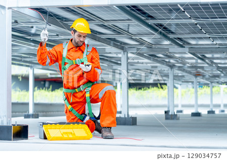 Professional technician worker or engineer look at tools for maintenance or check system under solar cell panel. 129034757