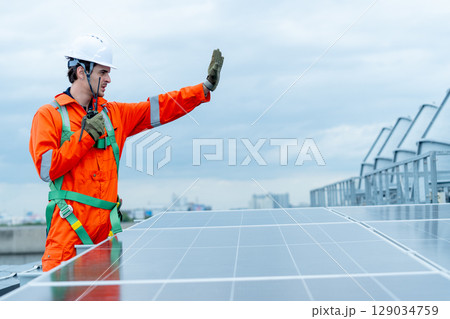 Professional technician worker or engineer stand near solar cell panel during check or maintenance in area of factory or rooftop building and show hand sign of prohibit to do somethings. Professional technician worker or engineer stand near solar cell panel during check or maintenance in area of factory or rooftop building and show hand sign of prohibit to do somethings. 129034759
