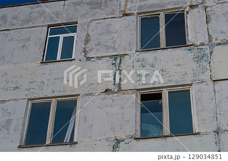 Wall of facade of old panel multi-storey building, joints of which began to diverge and were covered with large cracks. Emergency condition of dilapidated residential building or industrial building 129034851