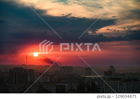 Dramatic sunset sky over city skyline with clouds. Dramatic sunset sky over city skyline with clouds. 129034875