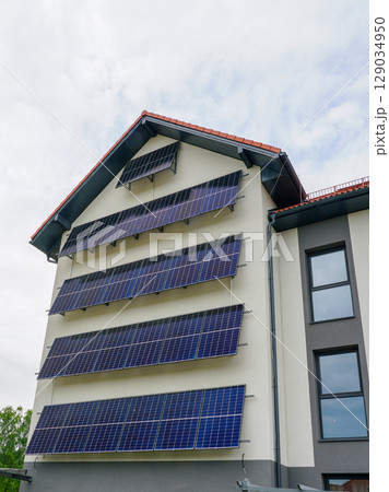 Modern Building with Vertical Solar Panels Installed on Facade for Renewable Energy Modern Building with Vertical Solar Panels Installed on Facade for Renewable Energy 129034950