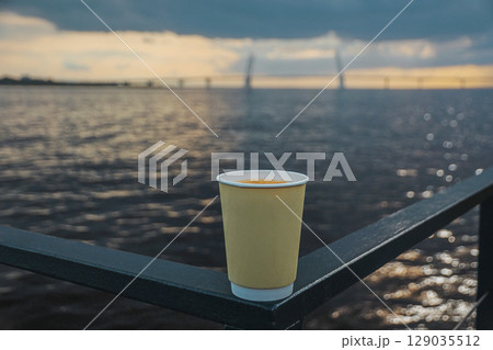cup of drink coffee of trendy cream color against on shore of bay with Vantiv bridges in blur cup of drink coffee of trendy cream color against on shore of bay with Vantiv bridges in blur 129035512