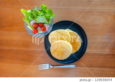 パンケーキとサラダが並ぶ爽やかな朝食の食卓 パンケーキとサラダが並ぶ爽やかな朝食の食卓 129036054