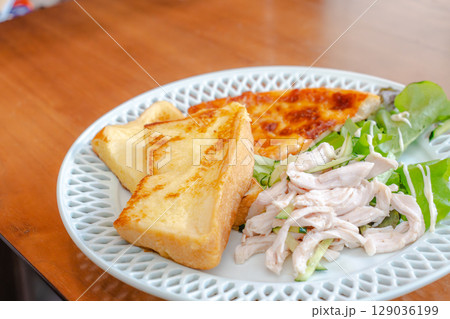 フレンチトーストとサラダチキン、ピザを盛り付けた朝食プレート 129036199