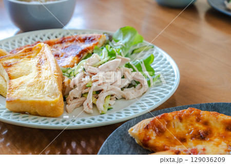 フレンチトーストとサラダチキン、ピザを盛り付けた朝食プレート 129036209