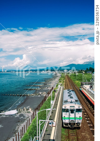 室蘭本線を走るキハ40形と海辺の景色 129036734