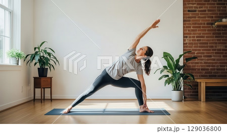 Woman Practicing Yoga in a Serene Indoor Space 129036800