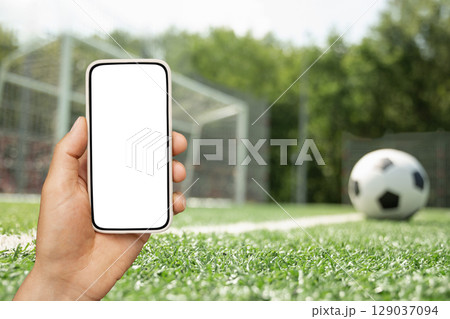 Man use mobile phone. of football on field as background Man use mobile phone. of football on field as background 129037094