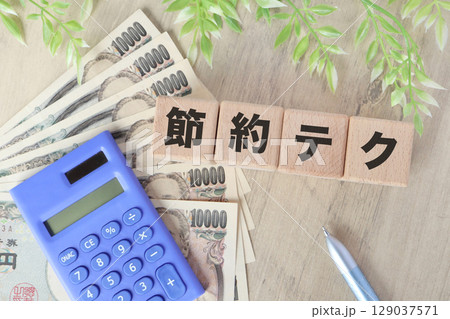 節約テクニックと1万円札と電卓のイメージ写真 129037571