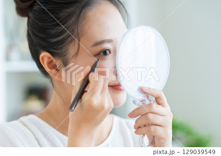 アイライナーを使う若い女性 アイライナーを使う若い女性 129039549