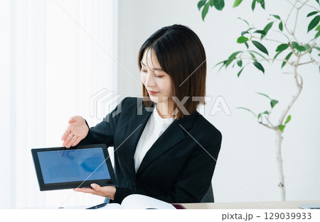 タブレットを見せるビジネスウーマン 129039933