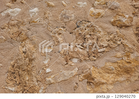 Textured wall in Crete with embedded stones, unique stone wall surface, natural background 129040270