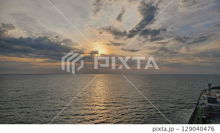 Cargo ship at sunset, view from bridge, maritime trade Cargo ship at sunset, view from bridge, maritime trade 129040476