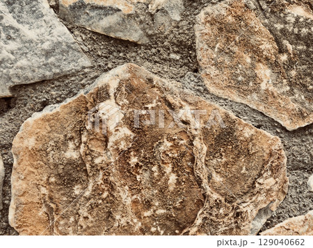 Stone wall texture background with natural masonry and cement joints 129040662