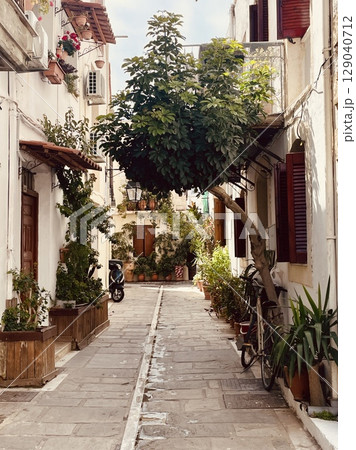 Cozy streets of the old town in Rethymno, filled with a large number of potted flowers 129040712