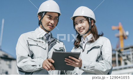 建設現場でタブレットを見る男女のビジネスパーソン 129041055