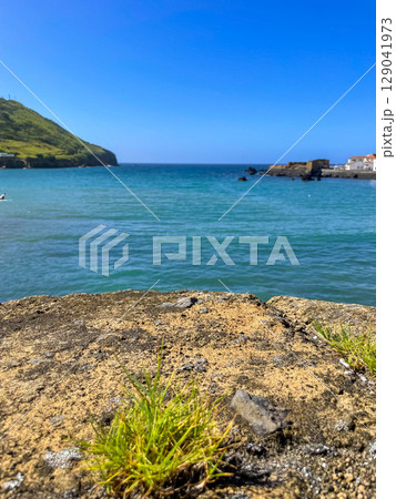 Ocean waves reach the shore of Horta, Faial Island, Azores 129041973