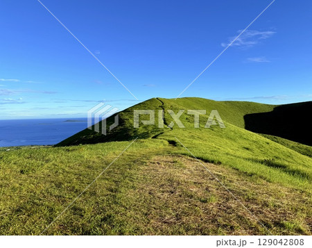 鬼岳の稜線と広がる緑の丘と青空 129042808