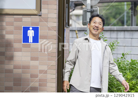 公衆トイレから笑顔で出てくる男性 129042915