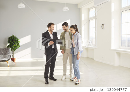 Realtor man meets couple, male licensed real estate agent, salesperson advertising property, helping 129044777