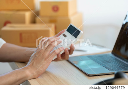 E-commerce entrepreneur using smartphone for order management at home office E-commerce entrepreneur using smartphone for order management at home office 129044779