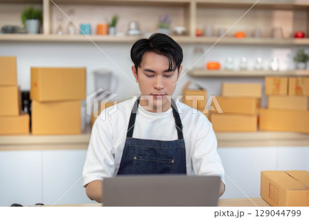 E-commerce entrepreneur focused on online order management in a bright workspace E-commerce entrepreneur focused on online order management in a bright workspace 129044799