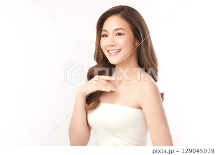 A beautiful young Asian woman with clean, fresh skin against a white background. Skincare, facial treatment, cosmetology, beauty, and spa. An elegant portrait of an Asian woman. A beautiful young Asian woman with clean, fresh skin against a white background. Skincare, facial treatment, cosmetology, beauty, and spa. An elegant portrait of an Asian woman. 129045019