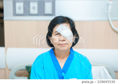 Elderly Woman with eye protective shield after eye surgery. Eye disease, Cataract, Glaucoma, Age Related Macular Degeneration, Diabetic Retinopathy, Vitreous, Lasik, World Glaucoma day and health Elderly Woman with eye protective shield after eye surgery. Eye disease, Cataract, Glaucoma, Age Related Macular Degeneration, Diabetic Retinopathy, Vitreous, Lasik, World Glaucoma day and health 129045530