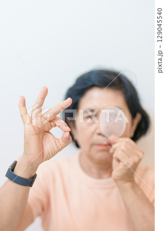 Elderly Woman with eye protective shield after eye surgery. Eye disease, Cataract,  Glaucoma, Age Related Macular Degeneration, Diabetic Retinopathy, Vitreous, Lasik, World Glaucoma day and health 129045540