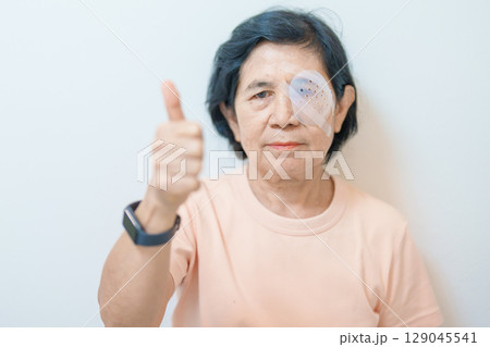 Elderly Woman with eye protective shield after eye surgery. Eye disease, Cataract,  Glaucoma, Age Related Macular Degeneration, Diabetic Retinopathy, Vitreous, Lasik, World Glaucoma day and health 129045541