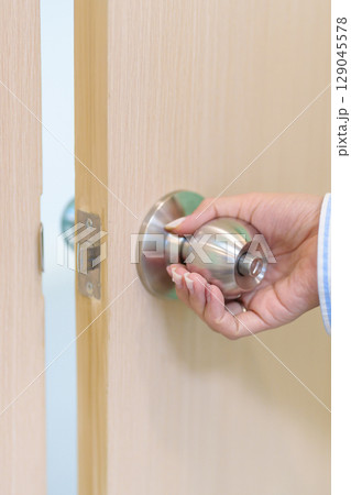 Woman hand holding doorknob and Open door. close the door knob 129045578