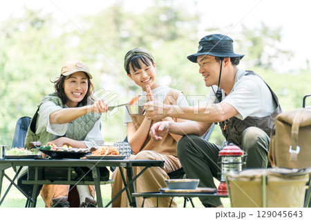 公園・キャンプ場でデイキャンプ・キャンプ・バーベキューを楽しむ仲良しのファミリー 129045643