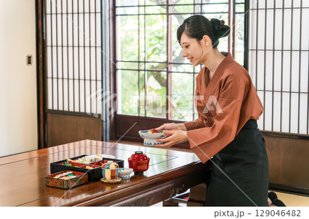 旅館の客室に料理を配膳する仲居さん,旅館スタッフ 旅館の客室に料理を配膳する仲居さん,旅館スタッフ 129046482