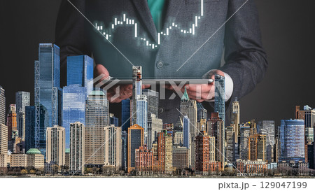 businessman hand writing on paper with graph chart and pen on city background with city buildings, skyscrapers and skyscrapers businessman hand writing on paper with graph chart and pen on city background with city buildings, skyscrapers and skyscrapers 129047199