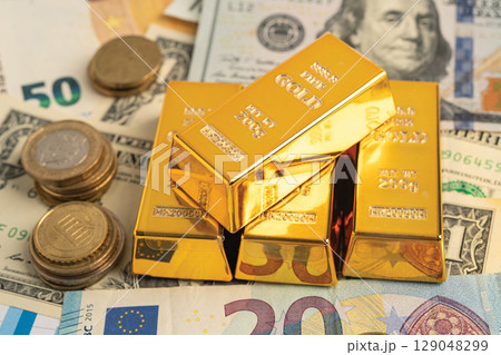 Gold bar on US dollar and Euro banknote, economy finance exchange trade investment. Gold bar on US dollar and Euro banknote, economy finance exchange trade investment. 129048299