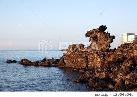 Jeju Yongduam Dragon Head Rock Famous Volcanic Rock Formation by the Sea with Scenic Coastline and Clear Sky 129049046