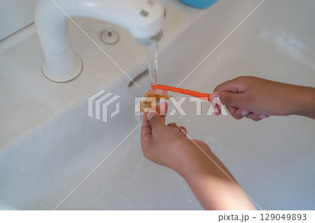 矯正装置(拡大床)を歯ブラシで磨く子供 129049893