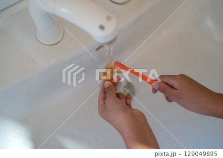 矯正装置(拡大床)を歯ブラシで磨く子供 129049895